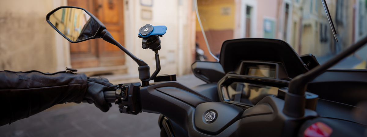 Quad Lock montat pe oglindă pe scooter, fotografiat outdoor, cu fundal real urban